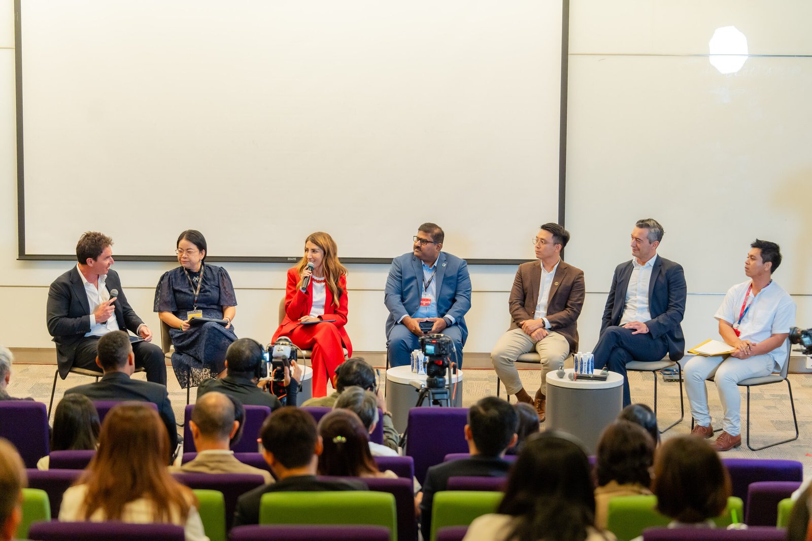 Nick McIntosh moderating the seven-person Nobel Prize Dialogue panel